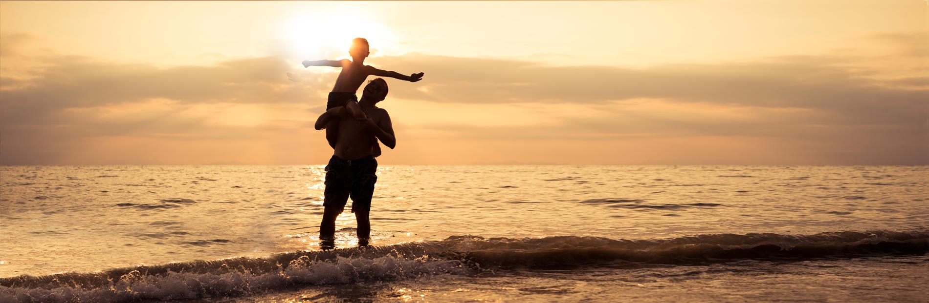 Father holding up son with arms spread wide