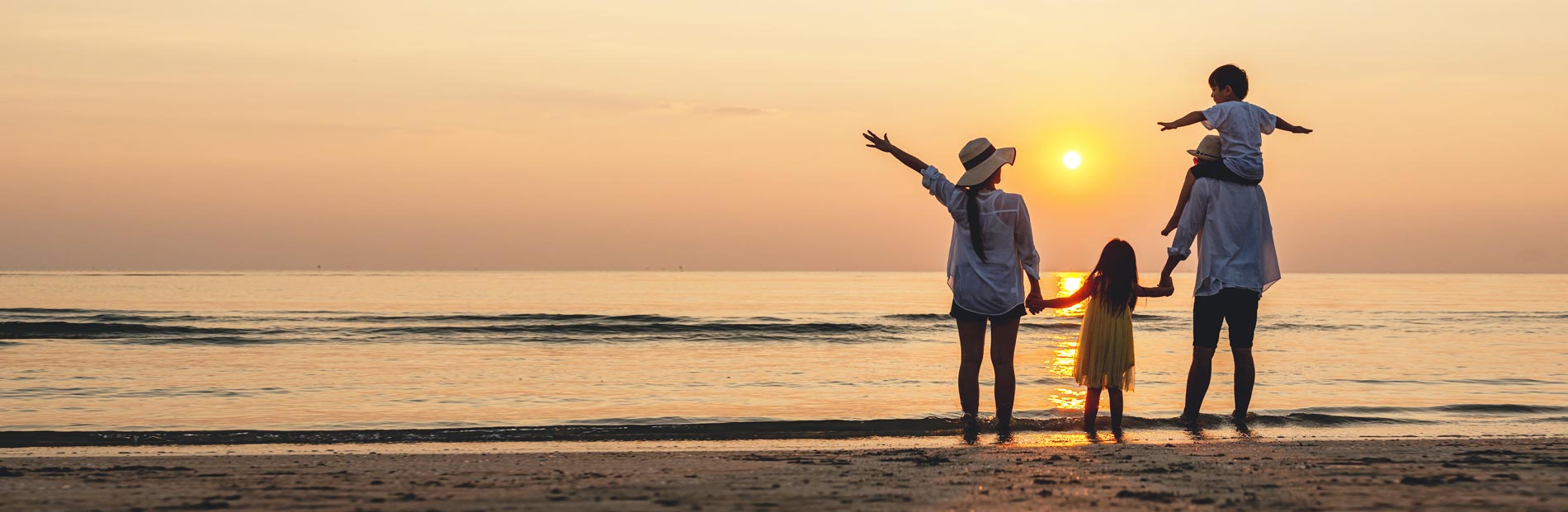 Family watching a sunset together at the ocean